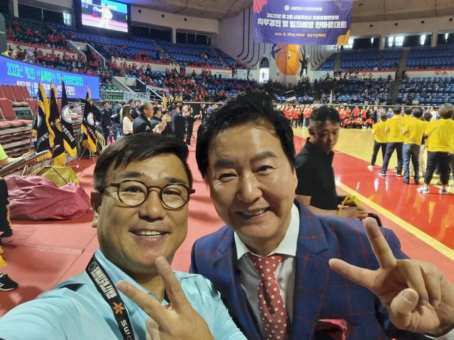 목조 무대 조명 아래 참석자들과 함께 찍은 단체 기념사진